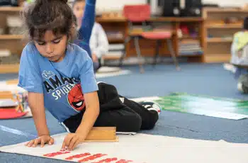 Montessori Kindergartner Working On a Floor Puzzle